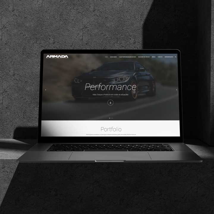 Laptop exibindo a página inicial do site da Armada Performance, com a imagem de um carro esportivo ao fundo, simbolizando o desenvolvimento e design de sites para empresas de performance automotiva.